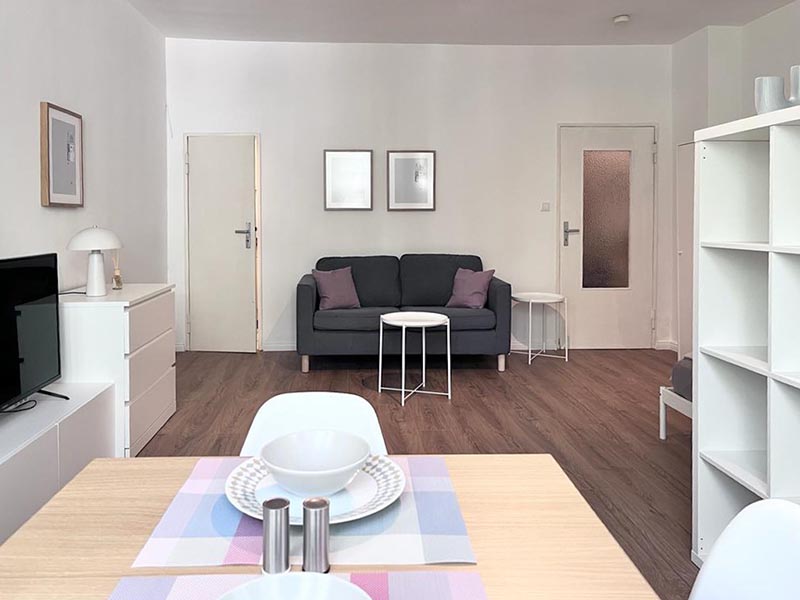 Altbau-Flur in Berlin mit kräftiger Wandfarbe und Parkettboden